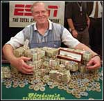 Dan Harrington smiles with piles of cash.